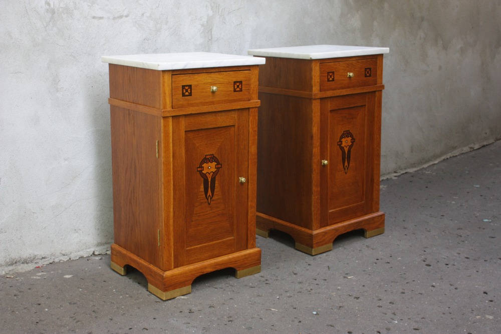 Dwie polskie secesyjno-art dekowskie szafki nocne, datowane na lata 1915-20. Zawierają w sobie cechy obu stylów łącząc roślinną ornamentykę z geometrycznością charakterystyczną dla art deco
